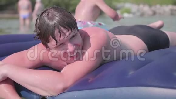 一对年轻的父子用充气床垫在海里洗澡积极的情绪夏日炎炎视频的预览图