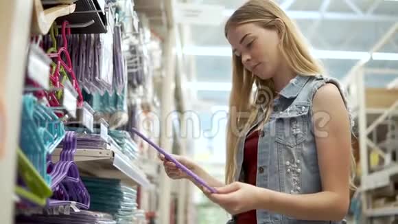 女购物者在一家商店里选择衣架作为衣服特写视频的预览图