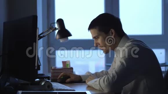 愤怒的商人穿着正式服装晚上在办公室用电脑工作然后扔报纸3840x2160视频的预览图