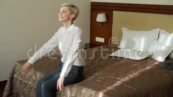 微笑的女商人跌倒躺在床上在酒店房间里放松旅游商业和人的概念视频的预览图