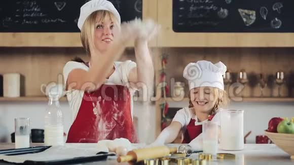 马瑟和女儿在厨房玩得开心他们准备圣诞饼干把面粉倒在桌子上家庭日视频的预览图