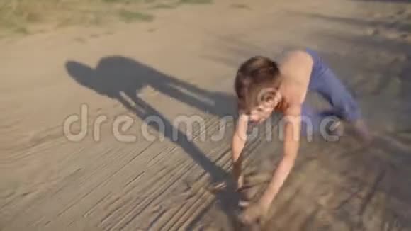 快乐的孩子在草原的尘土和沙滩上四脚跳跃自由玩耍视频的预览图