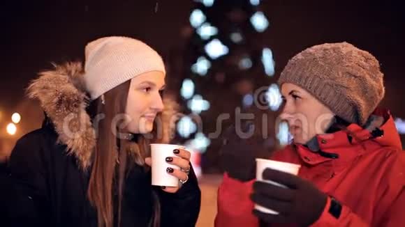 年轻的女孩在公园里喝咖啡笑着外面的冬天咖啡时间圣诞节视频的预览图
