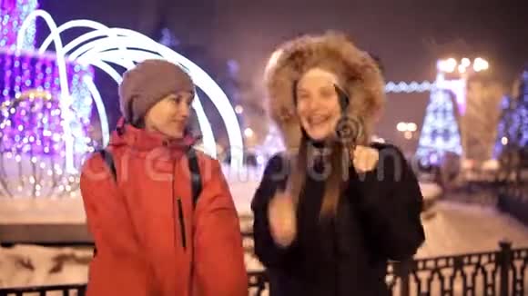 小女孩在冬天走在靠近圣诞树的城市中心广场上假日雪欢乐视频的预览图