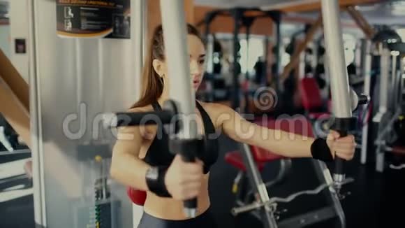 年轻漂亮的黑发女孩留着长发在健身中心做蝴蝶锻炼4千克视频的预览图
