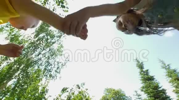 快乐的小兄弟姐妹在夏日牵着手在公园里奔跑视频的预览图