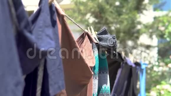 清洁洗衣服挂在电线上与衣服钉和模糊的春天自然背景在村庄视频的预览图
