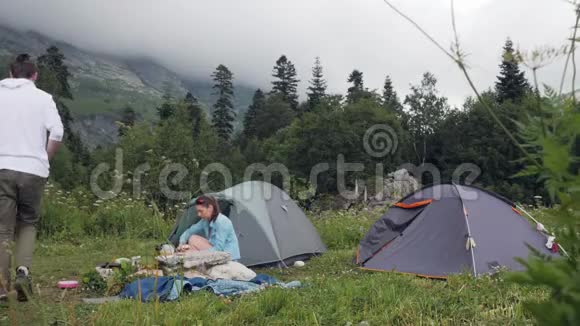 游客夫妇在山上的露营帐篷里休息视频的预览图