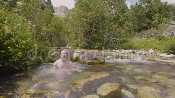 在炎热的夏日里年轻人沐浴在山河的水中视频的预览图