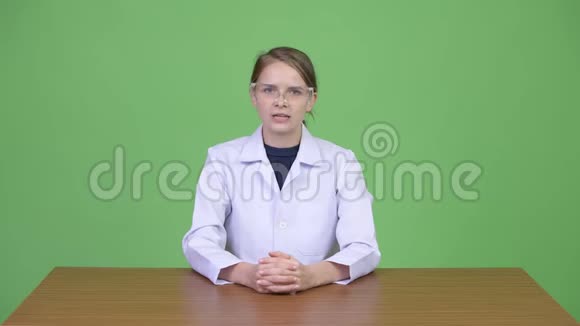 年轻漂亮的女医生戴着防护眼镜在解释视频的预览图