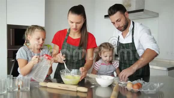 父母教孩子做饭他们教孩子们如何烹饪面团视频的预览图