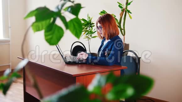 年轻女性办公室经理用笔记本电脑打印文本视频的预览图
