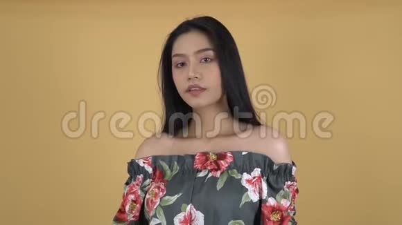 穿着花型衬衫的亚洲女孩的特写使她的黑色长发变平视频的预览图