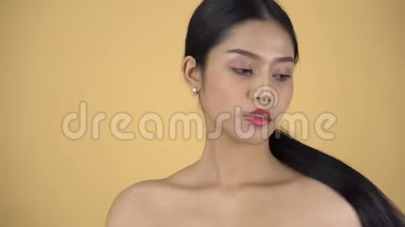 亚洲女孩赤裸的肩膀和长长的黑色马尾辫被隔离在背景上视频的预览图