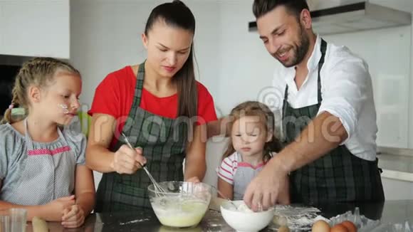 父母教孩子做饭他们教孩子们如何烹饪面团视频的预览图