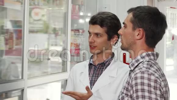 开朗的药剂师帮助男性顾客选择购买的产品视频的预览图