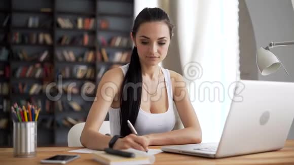 聪明的女性在办公桌和电脑前写作视频的预览图