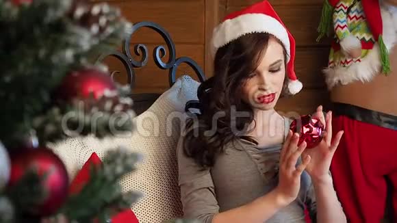 穿着圣诞服装的快乐年轻女士在房间里玩着挂满新年的五彩球视频的预览图