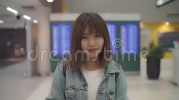 慢动作快乐的亚洲女人微笑着在国际机场的候机楼女游客视频的预览图