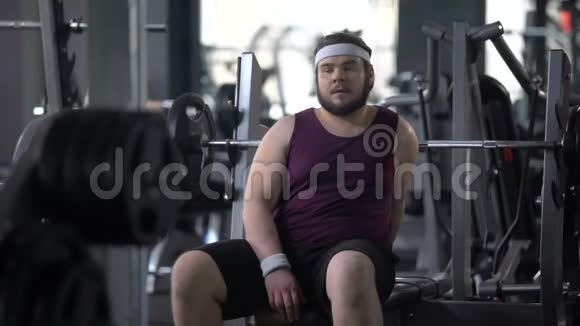 疲劳的胖子在锻炼后休息锻炼肌肉训练视频的预览图