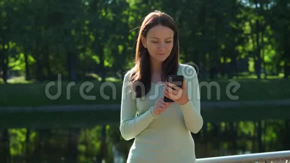 站在阳光下的智能手机美女画像视频的预览图