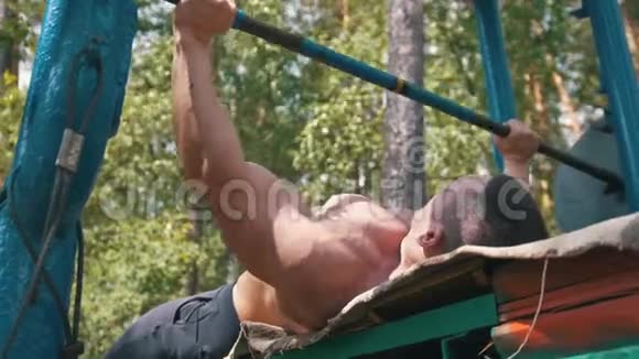 肌肉健美者在森林户外举起巨大的大横杆视频的预览图