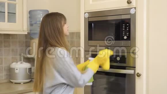 美丽的家庭主妇用清洁剂清洁烤箱门视频的预览图