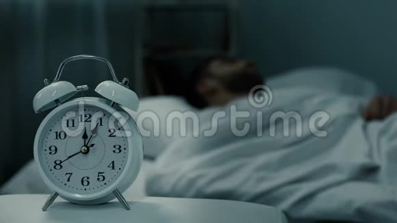 床钟显示午夜接近睡觉的人在床上休息时间健康的睡眠视频的预览图