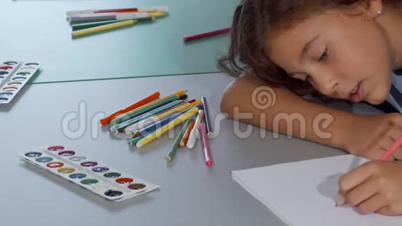 快乐的小女孩一边画画一边微笑着视频的预览图
