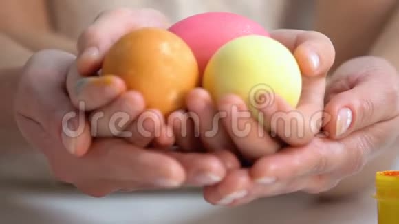 母亲牵着女儿的手手里拿着色彩鲜艳的复活节彩蛋视频的预览图