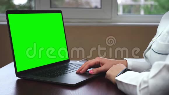 一位医生在一台带有绿色屏幕的笔记本电脑上工作的特写镜头科学家使用带有绿色屏幕色键的笔记本电脑视频的预览图