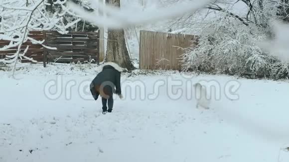 一位金发碧眼的年轻女子在白雪皑皑的公园里和儿子玩耍视频的预览图