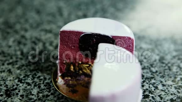 半紫色釉面慕斯迷你蛋糕剪裁的特写全景视频的预览图