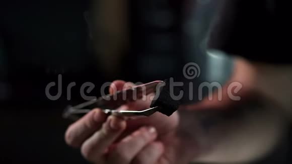 一个人在一个钩子酒吧里拿着火钳给胡克吸烟概念视频的预览图