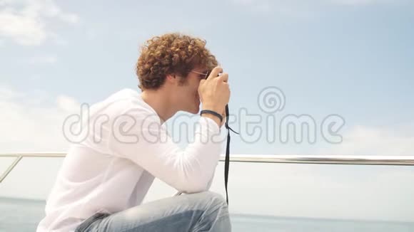 在游艇上很有魅力的一对年轻人正在拍他女朋友的照片视频的预览图
