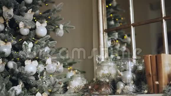 完美圣诞装饰壁炉架的特写镜头配有配件和带银球和绿色新年树视频的预览图