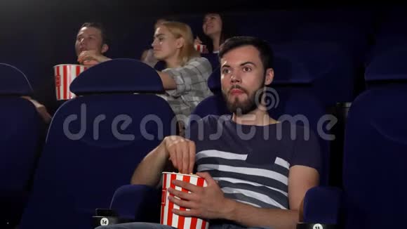 在电影院看电影时一个快乐的年轻人竖起大拇指视频的预览图
