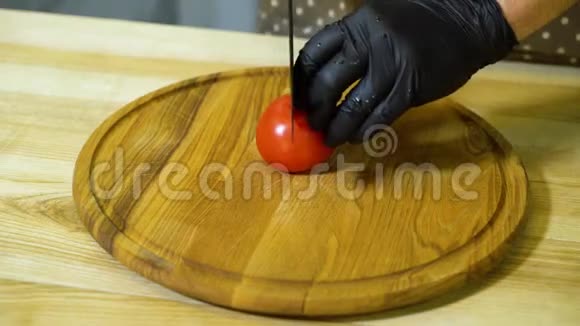 厨师手在圆木切割板上切割番茄的特写镜头视频的预览图