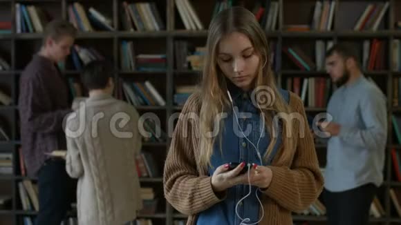 带着耳机在图书馆听音乐的女孩视频的预览图