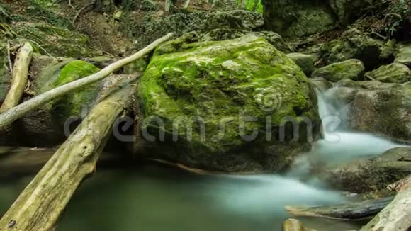 时间推移的山河被覆盖着绿色苔藓的巨大天然石头所包围视频的预览图