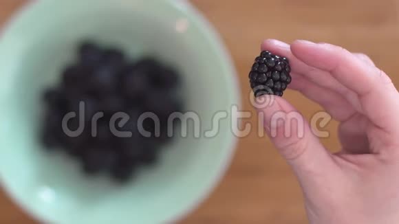 一个女人手把黑莓放在碗里把焦点从手到碗视频的预览图