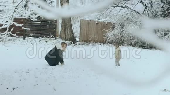 一位金发碧眼的年轻女子在白雪皑皑的公园里和儿子玩耍视频的预览图