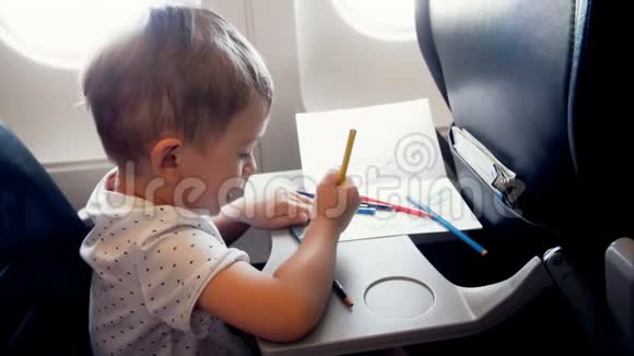 在飞机上一个微笑的小男孩在飞机上的乘客座位上视频的预览图