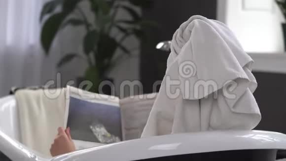 年轻的白种人女人头上戴着毛巾戴着太阳镜在一家美容院里接受水疗视频的预览图