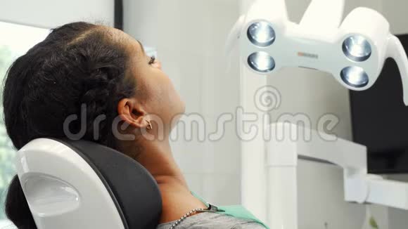 坐在牙科椅上的漂亮女病人对着镜头微笑视频的预览图