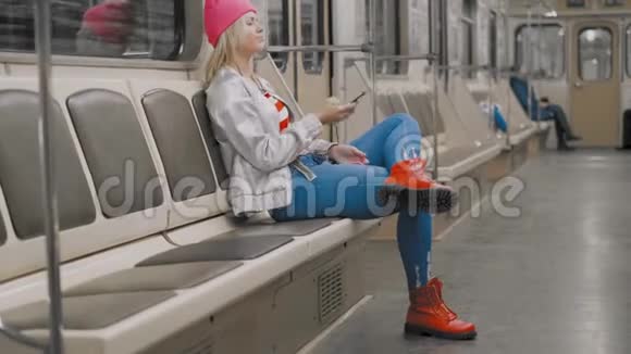 那个有趣的迷人的快乐的金发女孩在地铁的地铁里跳舞那个女人正在听音乐视频的预览图