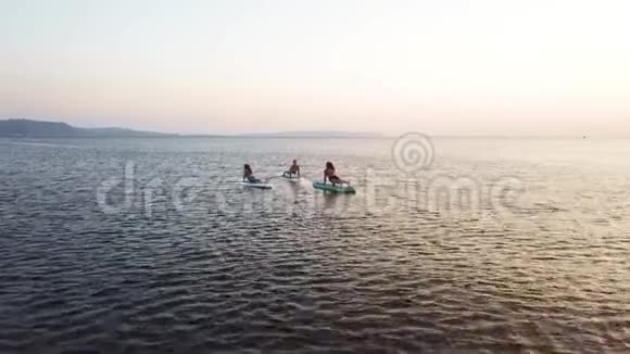 活跃的女孩在船上日落时练习瑜伽视频的预览图