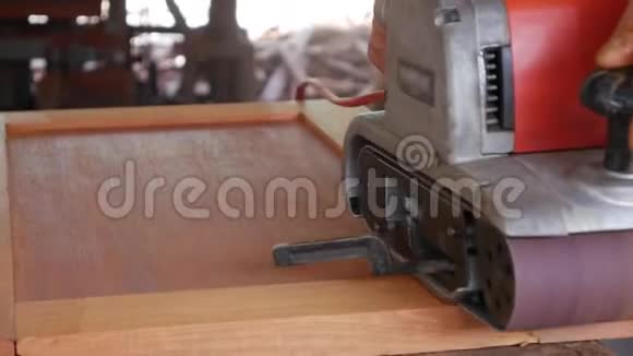 木工在车间工作时使用砂机工人用打磨抛光家具特写视频的预览图