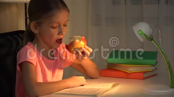 晚上在台灯读书学习女孩吃苹果读书视频的预览图