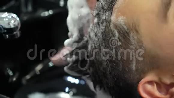 理发师男在理发店洗客户头视频的预览图